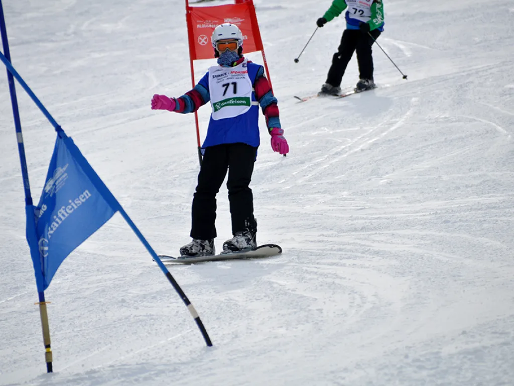 Snowboarderin mit Startnummer 71 neben dem blauen Tor.
